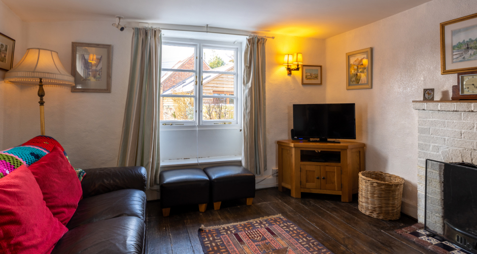 Living room with sofa, TV, and small window.